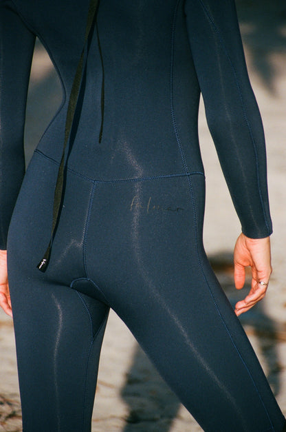 Close-up of a person wearing a dark blue wetsuit with a blurred background